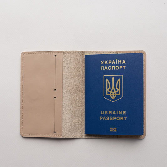 Beige leather passport cover Doco open with a passport tucked inside