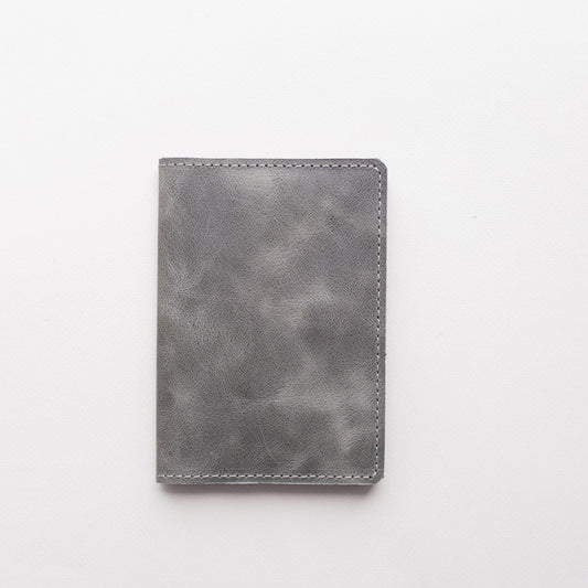 Silver grey vintage-effect leather passport cover on a light background
